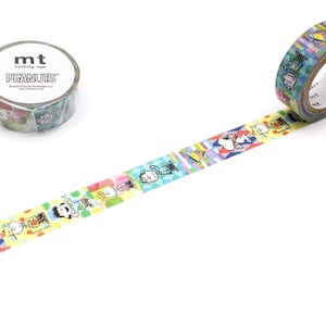 Könnte beinhalten: Zwei Rollen dekoratives Washi-Tape mit Peanuts-Charakteren. Eine Rolle ist abgerollt und zeigt ein farbenfrohes Muster der Charaktere auf weißem Hintergrund. Die andere Rolle ist intakt, mit den Logos "mt" und "PEANUTS" sichtbar.