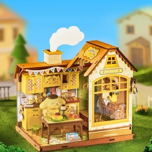 May include: A miniature wooden dollhouse kitchen in yellow and brown tones. The house has a chimney with a white smoke plume, a small table, and a cartoon character. The house has a sign that says "Pompompurin".