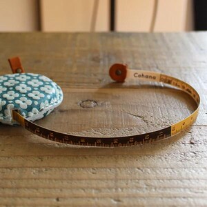 a measuring tape and a pillow on a wooden table