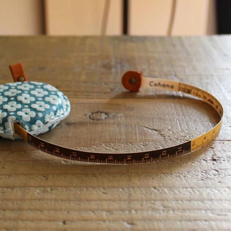 a measuring tape and a pillow on a wooden table