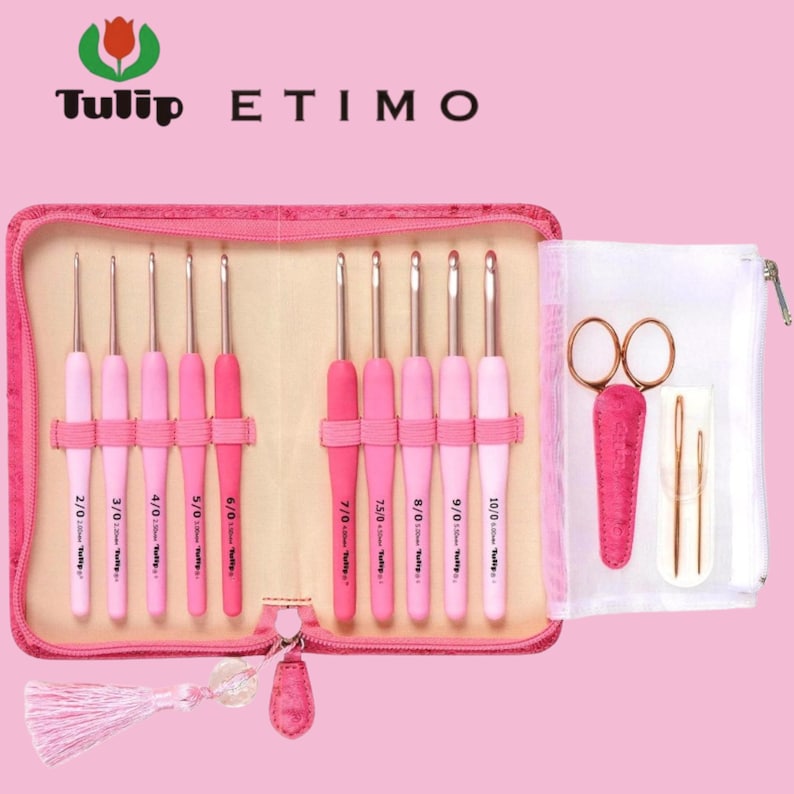 Op de afbeelding: Een roze haaknaaldset met de tekst "Tulip ETIMO". De set bevat verschillende maten haaknaalden, een schaar en naalden, allemaal opgeborgen in een roze etui met ritssluiting. De haken hebben roze handvatten en zilveren metalen punten.