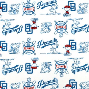 May include: White fabric with a repeating pattern of Peanuts characters, baseballs, and text. The design features Snoopy, Charlie Brown, and the word "Peanuts" in blue script. Baseball bats and the text "Since 1950" are also included.