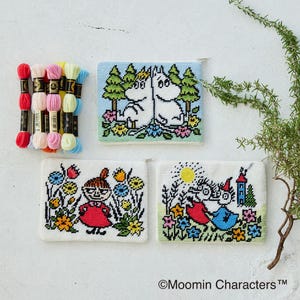 May include: Three small, white cross-stitch pouches with colorful Moomin character designs. The pouches feature images of Moomin characters in a garden setting. A collection of embroidery floss in various colors is also present.
