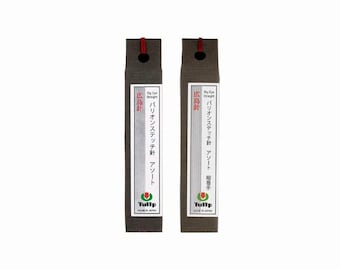 Könnte beinhalten: Zwei Big Eye Straight Nadelpakete. Die Verpackungen sind dunkelbraun mit einem weißen Etikett mit japanischem Text und der Marke "Tulip". Jede Verpackung hat ein rotes Band oben.