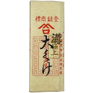 May include: An off-white rectangular package with Japanese text in red and black. The top features red characters above a stylized red shape. The package has a textured appearance and a vintage aesthetic.