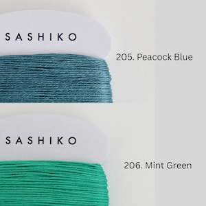 two spools of thread, each with a different color: one is green and the other is blue. The text above the spools indicates the color of the thread, with "SASHIKO" on the green thread and "205. Peacock Blue" on the blue thread. The text below the spools indicates the type of thread, with "206. Mint Green" on the green thread and "Mint Green" on the blue thread.