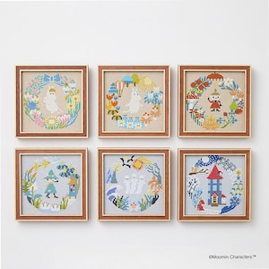 May include: Six framed cross-stitch artworks featuring whimsical scenes with characters and floral wreaths. Each square frame has a wooden border. The cross-stitch designs incorporate various colors, including blue, green, and orange, on a neutral background.