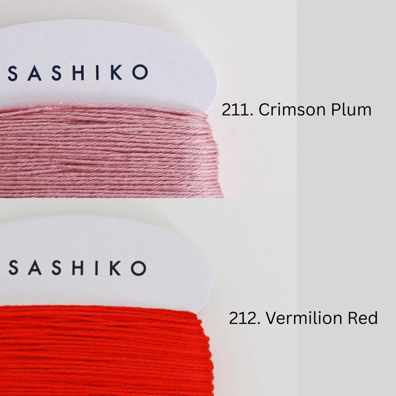 two spools of thread, each with a different color: one is a pinkish-red color and the other is a deep red color. The text above the spools reads "SASHIKO" and "211. Crimson Plum" respectively, indicating the brand and color of the thread.