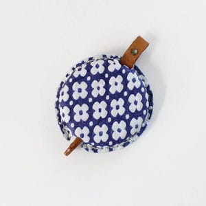 a blue and white flowered purse with a wooden handle