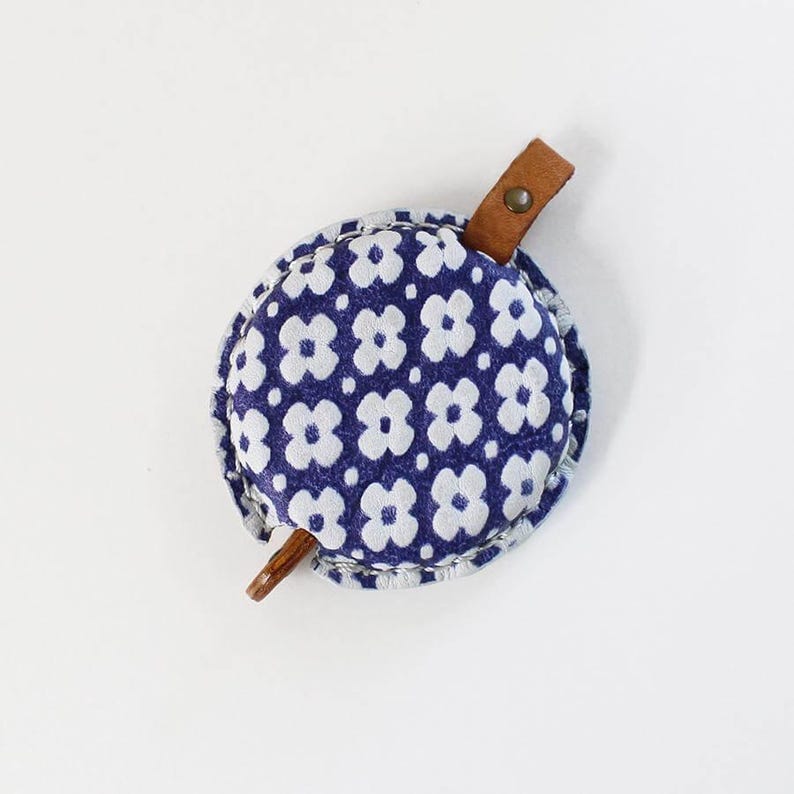 a blue and white flowered purse with a wooden handle