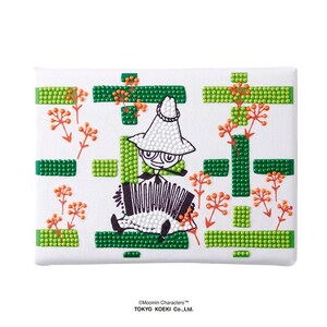 May include: A white rectangular canvas featuring a diamond painting of Snufkin playing an accordion. The design includes green beaded geometric bars and orange beaded floral sprigs. The text Moomin Characters and TOKYO KOEKI Co., Ltd. is printed below.