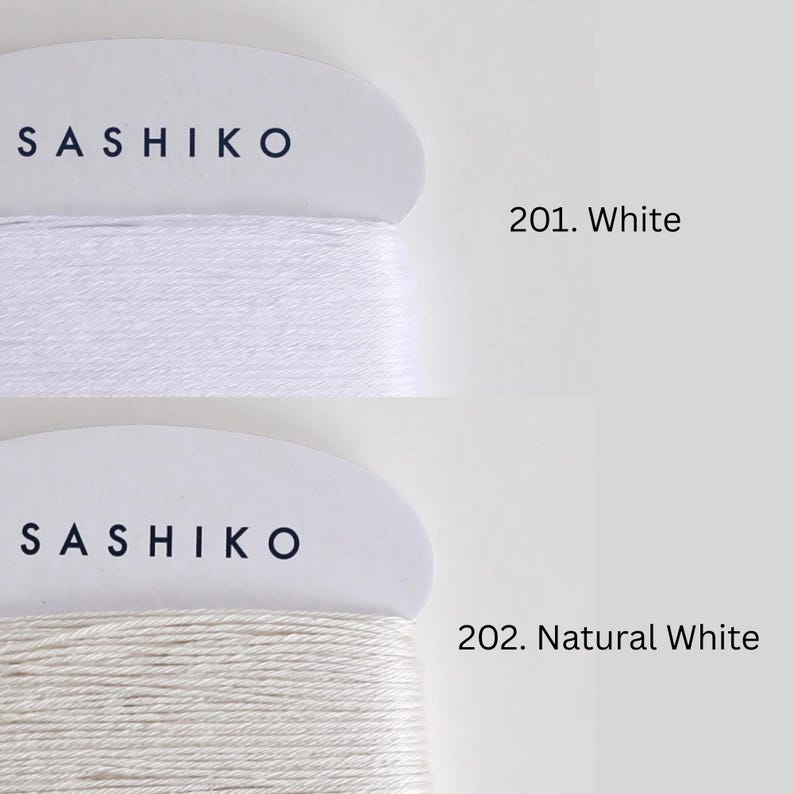 two spools of yarn, each with a different color: one labeled "SASHIKO" in black text on a white background, and the other labeled "201. Natural White" in black text on a white background.