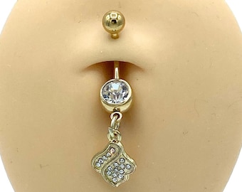 May include: Gold belly button ring with a clear crystal dangle and a small flower charm with clear crystals.