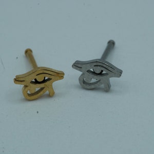 Puede incluir: Dos anillos de nariz con un diseño de ojo de Horus. Uno es dorado y el otro es plateado.