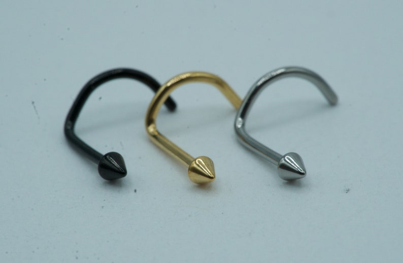 K&ouml;nnte beinhalten: Drei Nasenringe mit einer spitzen Spitze. Die Ringe sind aus Metall und in Schwarz, Gold und Silber erh&auml;ltlich.
