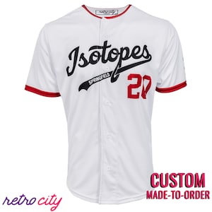 May include: White baseball jersey with red trim and black lettering. The jersey says "Isotopes Springfield 20" on the front.