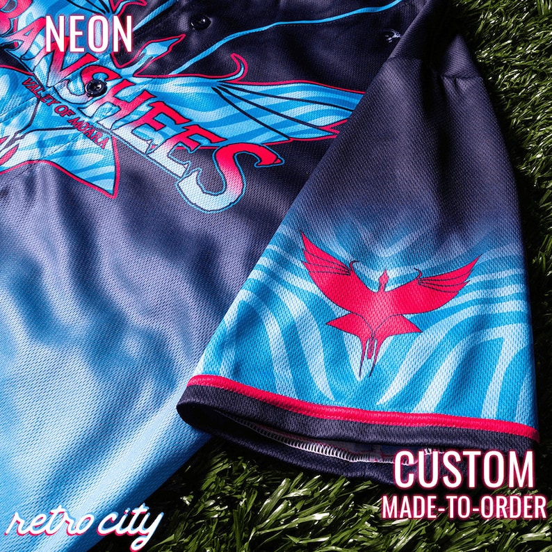 May include: A black and blue baseball jersey with a red and white design. The jersey has the words "NEON" and "ANCHEES" on the front. The sleeve has a red bird design. The text "CUSTOM MADE-TO-ORDER" is on the bottom of the image. The text "retro city" is on the bottom left of the image.