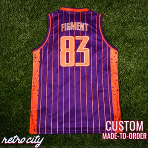 May include: Purple and orange basketball jersey with white vertical stripes and orange stars on the sides. The back of the jersey has the text "FIGMENT" and the number "83" in white outlined in orange. The bottom of the jersey has the text "CUSTOM MADE-TO-ORDER".