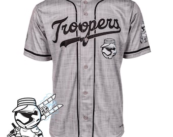 May include: A grey baseball jersey with black trim and buttons. The word "Troopers" is across the chest in black script. A cartoon image of a Stormtrooper is on the right sleeve and a logo is on the left sleeve. The words "Custom Made-to-Order" are in pink.