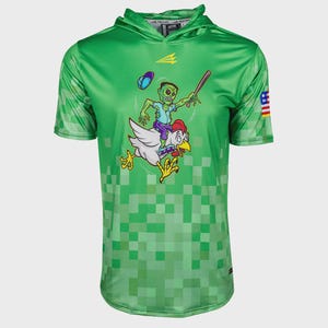 Puede incluir: Camiseta con capucha verde de manga corta con un patrón pixelado. Un zombi de dibujos animados montado en un pollo y sosteniendo un bate de béisbol está impreso en la parte delantera. La camiseta tiene un pequeño parche de la bandera americana en la manga.