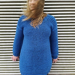 May include: A blue knitted jumper with a loose fit and a textured pattern. The jumper is long-sleeved and has a round neckline.
