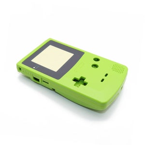 Könnte beinhalten: Eine leuchtend grüne Game Boy Color-Gehäuse-Ersatzhülle. Die Hülle ist aus Kunststoff und hat einen schwarzen Bildschirm und Knöpfe.