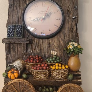 May include: A rustic wooden wall clock with a farm theme. The clock face is surrounded by a wooden frame with the text "Farm Fresh Fruits & Veggies". The clock features a variety of miniature fruits and vegetables, and a small clock at the top. The clock is 12 inches in diameter.
