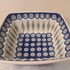 May include: Square ceramic serving bowl with a white base and a blue and brown floral design. The rim features a repeating pattern of blue circles with brown centers. The interior has a central square of blue circles and stylized leaf shapes.