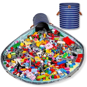 Puede incluir: Una bolsa de almacenamiento de juguetes a rayas azules y blancas con cierre de cord&oacute;n y un contenedor de almacenamiento cil&iacute;ndrico a juego. La bolsa est&aacute; abierta, llena de una variedad de bloques de juguetes coloridos. La bolsa tiene aproximadamente 122 cm de di&aacute;metro.