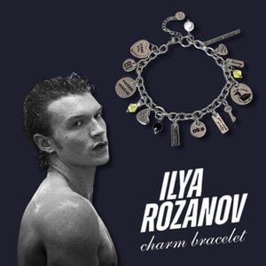 Puede incluir: Una pulsera de plata con dijes variados, incluyendo formas de corazón, círculo y rectángulo. Algunos dijes tienen texto como "Gimme Kiss" y "oke". La pulsera se muestra con el texto "ILYA ROZANOV charm bracelet" en blanco.