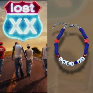 May include: A blue and red beaded bracelet spelling "LOST XX". The bracelet has blue disc beads, red star beads, and white letter beads. The bracelet is displayed against a brown backdrop.