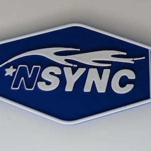 May include: Blue and white keychain with a star-shaped charm. The keychain features the word "NSYNC" in white letters with a white flame design above the text.