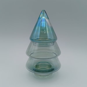 Puede incluir: Un adorno de árbol de Navidad de vidrio de tres niveles con un acabado azul iridiscente.