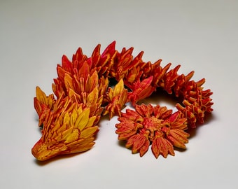 May include: A 3D printed, red and yellow flower sculpture. The sculpture is made up of many individual flowers that are connected together. The flowers are arranged in a circular pattern.