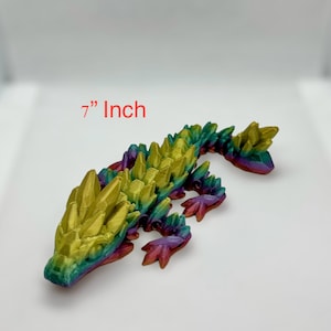 May include: A 7-inch long, multi-colored, 3D printed lizard with a crystal-like texture. The lizard is a vibrant mix of green, yellow, purple, and red.