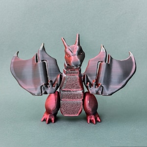 May include: A red and black 3D printed dragon figurine with wings spread out. The dragon has a textured surface and a detailed design.