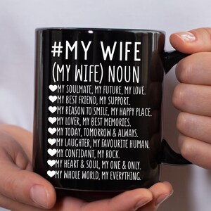 以下が含まれることがあります： 黒いセラミックマグカップ。白い文字で「#MY WIFE (MY WIFE) NOUN」と書かれています。マグカップには、「My Soulmate, My Future, My Love」や「My Whole World, My Everything」などの愛情あふれる説明が記載されています。