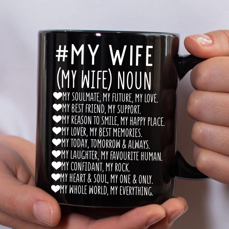 以下が含まれることがあります： 黒いセラミックマグカップ。白い文字で「#MY WIFE (MY WIFE) NOUN」と書かれています。マグカップには、「My Soulmate, My Future, My Love」や「My Whole World, My Everything」などの愛情あふれる説明が記載されています。