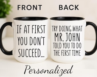 Może przedstawiać: Biały ceramiczny kubek z czarnym uchwytem i obramowaniem. Przód kubka głosi „IF AT FIRST YOU DON'T SUCCEED...”, a tył „TRY DOING WHAT MR. JOHN TOLD YOU TO DO THE FIRST TIME”. Słowo „Personalized” jest napisane na dole.