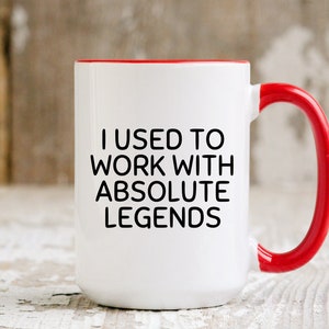 May include: White ceramic mug with a red rim and handle. The mug has black text that reads "I used to work with absolute legends."