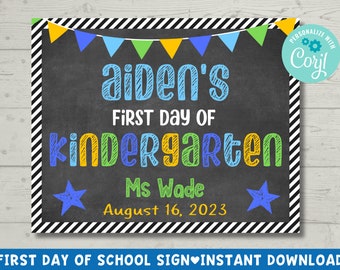 May include: A chalkboard sign with a black and white striped border. The sign says "aiden's First Day of Kindergarten" in colorful letters. The teacher's name, "Ms Wade", and the date, "August 16, 2023", are also written on the sign.