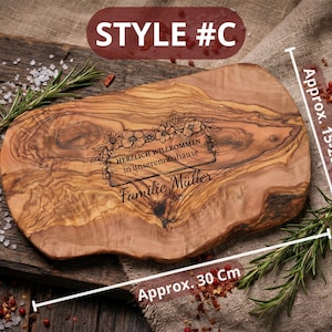 May include: Wooden serving board, approximately 12 inches long and 6-8 inches wide, with engraved text and floral design. The text reads "HERZLICH WILLKOMMEN in unserem Zuhause Familie M&uuml;ller Seit 2026". The board is on a wooden surface with rosemary and spices.
