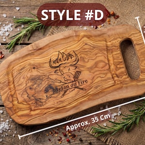 May include: Wooden cutting board, style #D, with a handle, measuring approximately 35 cm long and 20-30 cm wide. The board features an engraved bull design and the text "Stefan on Fire".