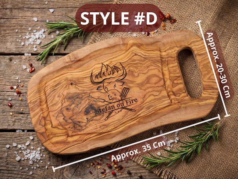 May include: Wooden cutting board, style #D, with a handle, measuring approximately 35 cm long and 20-30 cm wide. The board features an engraved bull design and the text "Stefan on Fire".
