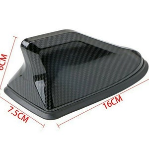 May include: Black carbon fiber car antenna fin with a 7.5 inch by 16 inch measurement.