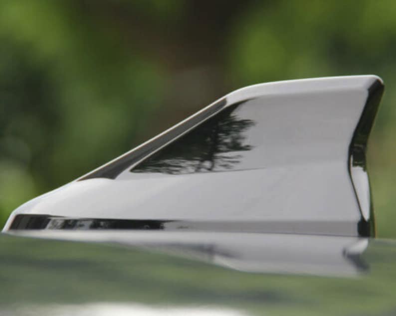 May include: A black car antenna fin, also known as a shark fin antenna, is a popular aftermarket accessory for vehicles. It is designed to improve radio reception and add a sporty look to the car.
