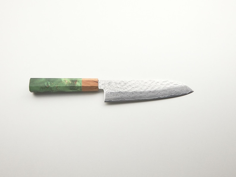 Puede incluir: Cuchillo de chef de estilo japon&eacute;s con una hoja plateada texturizada y un mango en tonos verdes, marrones y beige. Dise&ntilde;ado para cortar con precisi&oacute;n y preparar alimentos.