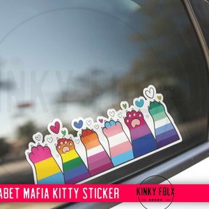 Puede incluir: Una pegatina con una fila de patas de gato coloridas con corazones, que representan la mafia del alfabeto. Las patas están dispuestas en una línea, cada una con un color y un diseño diferente, que representan diferentes orientaciones sexuales. La pegatina está en la ventana de un coche.