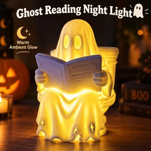 May include: A white ghost-shaped night light sitting on a toilet while reading a book. The figure emits a warm yellow glow from within. Text above reads Ghost Reading Night Light, with a crescent moon icon and Warm Ambient Glow text.
