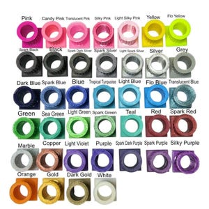 May include: A color chart displaying various small, square-based cylindrical objects in multiple shades. The text labels include Pink, Candy Pink, Translucent Pink, Silky Pink, Light Silky Pink, Yellow, Flo Yellow, Spark Black, Black, Spark Dark Silver, Spark Silver, Light Spark Silver, Silver, Grey, Dark Blue, Spark Blue, Blue, Tropical Turquoise, Light Blue, Flo Blue, Translucent Blue, Green, Sea Green, Light Green, Spark Green, Teal, Red, Spark Red, Marble, Copper, Light Violet, Purple, Spark Dark Purple, Spark Purple, Silky Purple, Orange, Gold, Dark Gold, and White.